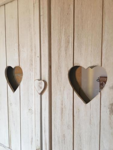 three heart shaped hooks hanging on a wooden wall at Agriturismo La Soglia Del Parco in Ranica