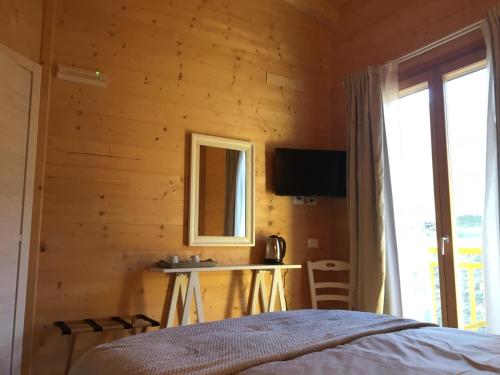 a bedroom with a bed and a desk and a window at Agriturismo La Soglia Del Parco in Ranica