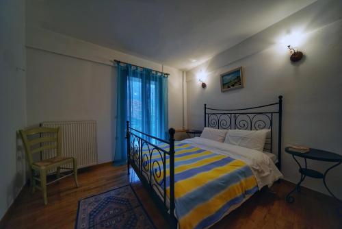 Elatos Guest House في إبتالوفوس: غرفة نوم بسرير وبطانية مخططة صفراء وزرقاء