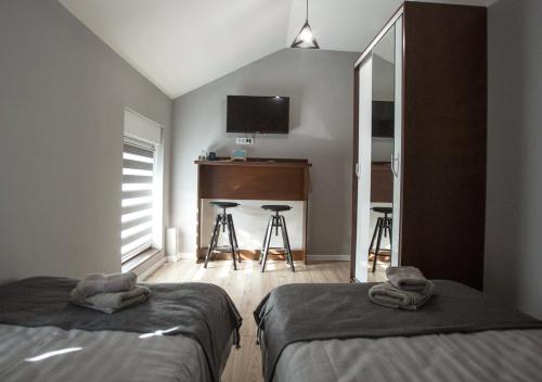 a bedroom with two beds and a desk and a television at Apartmani Zrenjanin in Zrenjanin