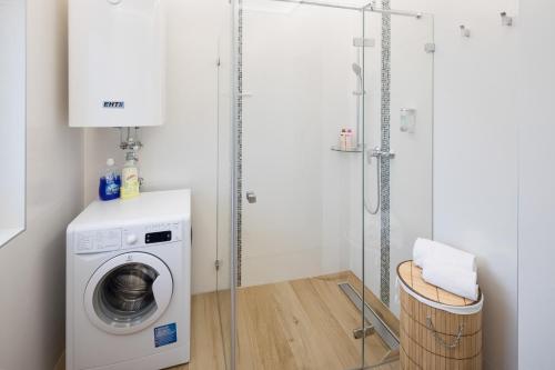 a laundry room with a washing machine and a shower at Design-Apartments Graz in Graz