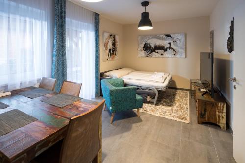 グラーツにあるDesign-Apartments Grazのデスク、ベッド、テーブルが備わる客室です。