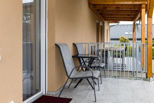 a patio with chairs and a table on a balcony at Design-Apartments Graz in Graz