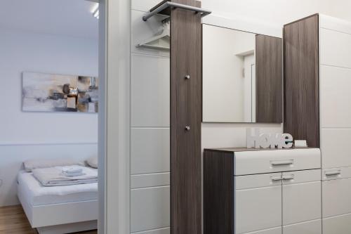 a dressing room with a mirror and a bed at Design-Apartments Graz in Graz