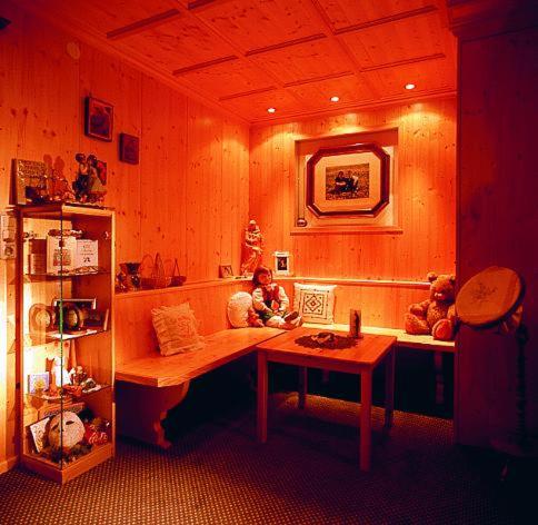 a room with a table and a shelf with teddy bears at Sporthotel Krone in Schoppernau