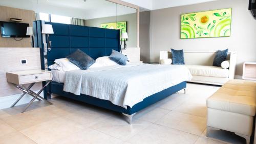 1 dormitorio azul con 1 cama grande y 1 sofá en Relais Sans Soucis & Spa, en Ronciglione