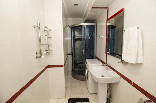 een witte badkamer met een wastafel en een spiegel bij Apartment on Pervomayskaya 15 in Pyatigorsk
