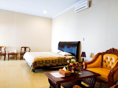 BaubauにあるNirwana Buton Villaのベッドルーム1室(ベッド1台、テーブル、椅子付)