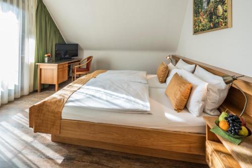 a bedroom with a bed and a desk with a television at Hotel - Landgasthof Rebstock in Nimburg