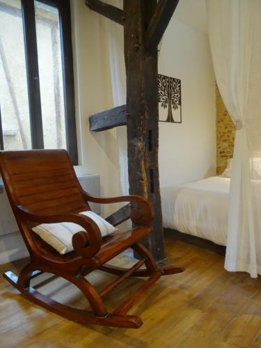 a wooden rocking chair in a room with a bed at Habitation Saint-Clar Vieille Ville in Bergerac
