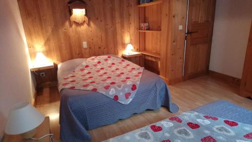 a bedroom with a bed with a blanket with hearts on it at Le Foueustarle in La Giettaz