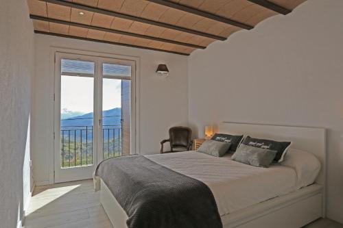 Habitación blanca con cama y balcón. en VENT DEL NORD, en Toses