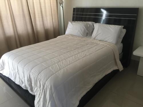 a large bed with white sheets and pillows at Pelican By The Sea in Pompano Beach