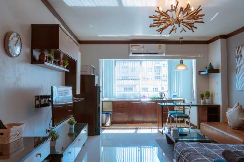 a living room with a couch and a table and a kitchen at ARMO Nimman in Chiang Mai