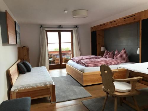 1 Schlafzimmer mit 2 Betten, einem Tisch und einem Stuhl in der Unterkunft Gästehaus Bartl in Rottach-Egern