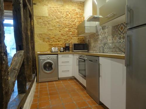 a kitchen with a washing machine and a washer at Habitation Saint-Clar Vieille Ville in Bergerac