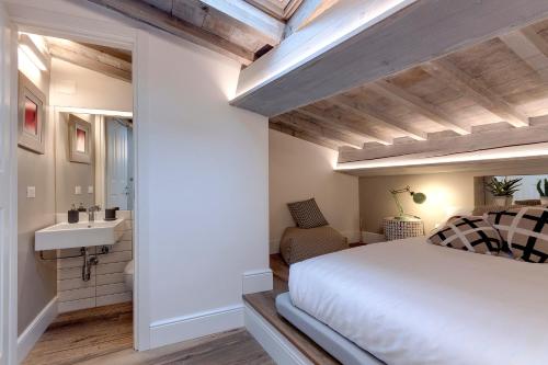 1 dormitorio con cama blanca y lavamanos en Mamo Florence - Parione Roof Terrace, en Florencia