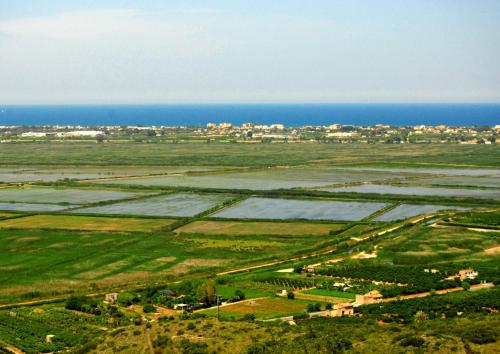 an aerial view of a field with the ocean at Complejo Bellavista Residencial in Pego