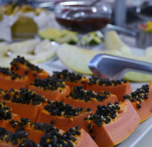 a plate of food with fruit on a table at Hotel Village Campinas in Campinas