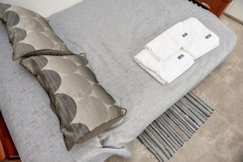 Una cama con colcha gris y una almohada. en Loft La Plata en La Plata