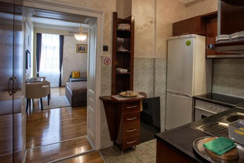 een keuken met een koelkast en een woonkamer bij Knez Mihailova Apartman in Belgrado
