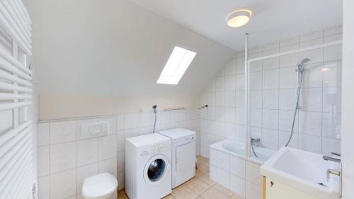 a white bathroom with a washing machine and a sink at Villapark de Paardekreek in Kortgene