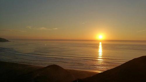 a sunset over the ocean with the sun in the sky at Tiny Apartment Las Puyas Ocean View in Boca Pupuya