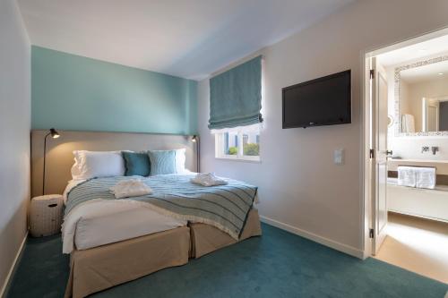 a bedroom with a bed and a flat screen tv at Vila Vita Parc Resort & Spa in Armação de Pêra