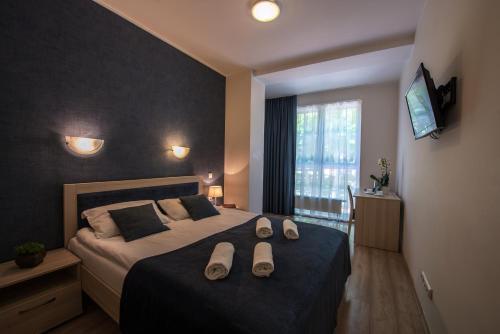 Un dormitorio con una cama con zapatillas. en Sanatorija ,,Tulpės", en Birštonas