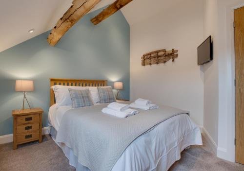 1 dormitorio con 1 cama con toallas en Côr Llew Coch, en Bala