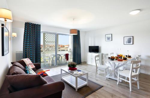 a living room with a couch and a table at Résidence Néméa Les Balcons des Pêcheurs in Mimizan-Plage