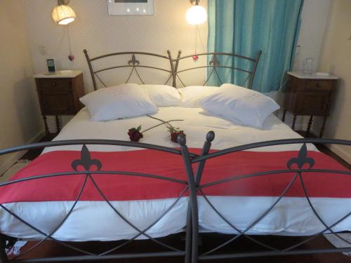 Saaxumhuizen的住宿－菲尼斯特雷住宿加早餐旅館，一张带红色和白色棉被的大床