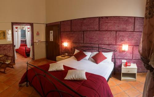 ein Schlafzimmer mit einem großen Bett und einer roten Backsteinwand in der Unterkunft Hotel Residence Confalone in Neapel