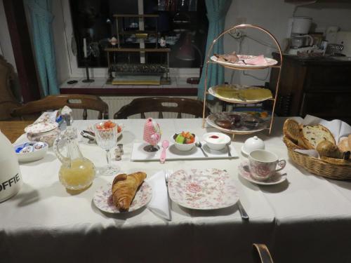 a table with a white table cloth with pastries and bread at Finisterre in Saaxumhuizen