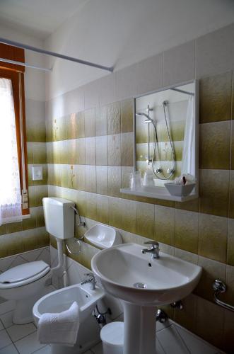 a bathroom with a sink and a toilet and a mirror at Aurora Residence in Lido Adriano