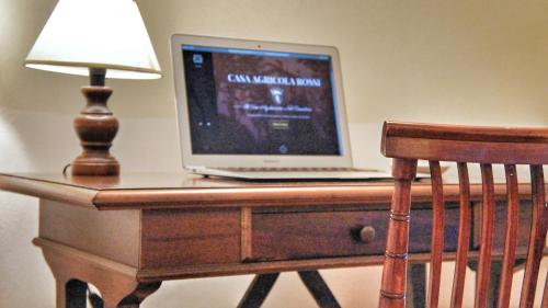 a laptop computer sitting on a desk with a lamp at Agriturismo Casa Agricola Rossi Appartamenti in Casentino in Soci