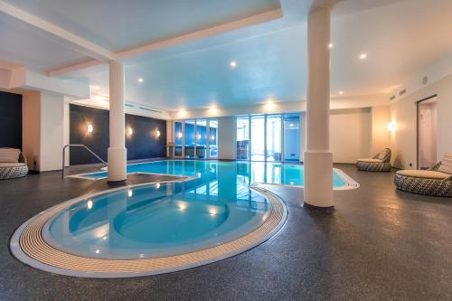 a pool in a hotel room with a hot tub at Moselromantik Hotel Kessler Meyer in Cochem