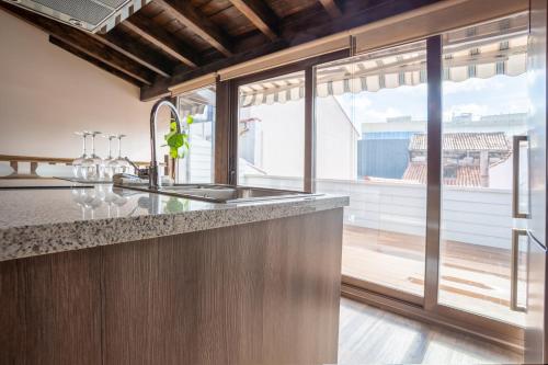 a kitchen with a sink and a large window at Plaza Mayor Apartamentos 10 in Valladolid
