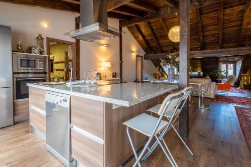 a kitchen with a counter and chairs in a room at Plaza Mayor Apartamentos 10 in Valladolid