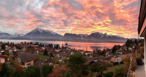 a view of a town with a lake and mountains at Otium-Oberhofen in Oberhofen am Thunersee