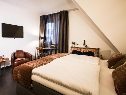 a hotel room with a bed and a chair at Boutique Hotel K7 in Bad Nauheim