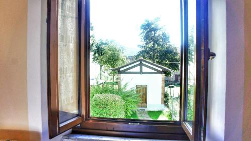 a window with a view of a house at Agriturismo Casa Agricola Rossi Appartamenti in Casentino in Soci