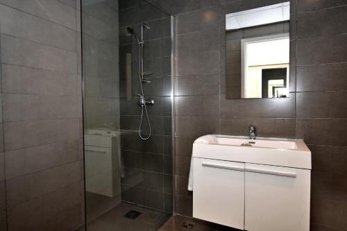 La salle de bains est pourvue d'une douche, d'un lavabo et d'un miroir. dans l'établissement City Living Suite TK 1 Rm 3, à San Ġiljan