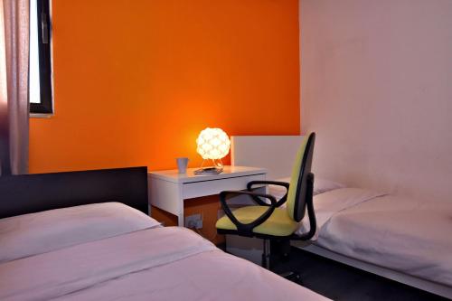 Cette chambre comprend deux lits et un bureau avec une chaise. dans l'établissement City Living Suite TK 1 Rm 3, à San Ġiljan