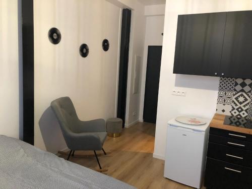 une chambre avec un lit, une chaise et un bureau dans l'établissement Marguerite, à Strasbourg