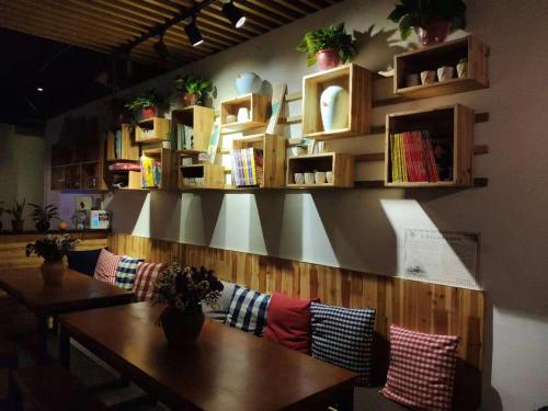 a dining room with a wooden table with pillows at Suzhou Blue Gate Youth Hostel in Suzhou
