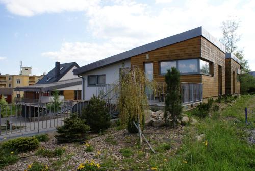a house with a wooden facade with a yard at Mountain Villas Polana in Smokovce