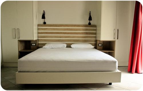 a bedroom with a large bed with red curtains at Altanahouse in Parga
