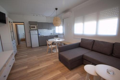 a living room with a couch and a kitchen at Camping Joan Bungalow Park in Cambrils