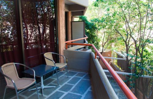 a balcony with a table and chairs on a house at Apollonia Hotel Apartments in Varkiza